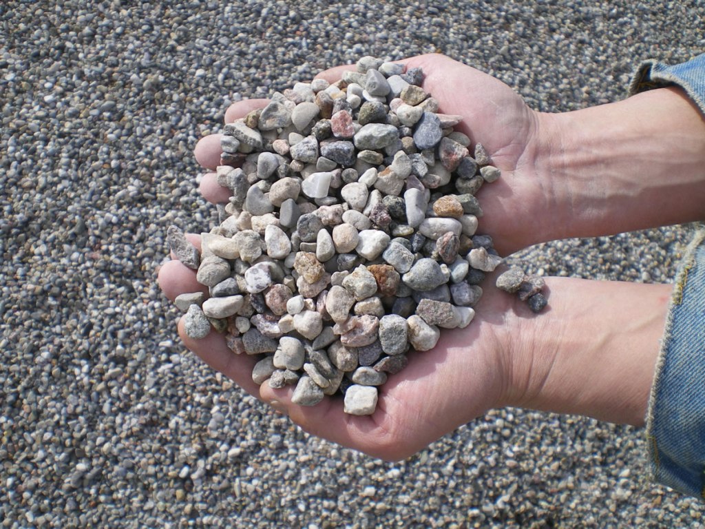 Pea-sized washed riverstone shown in two handfuls.